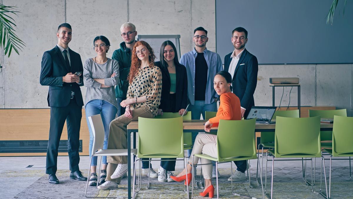 group of employees pose during business meeting in conference room